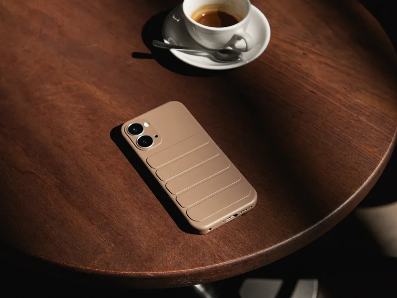 Telefon într-o husă de protecție pe o masă de lemn, lângă cafea